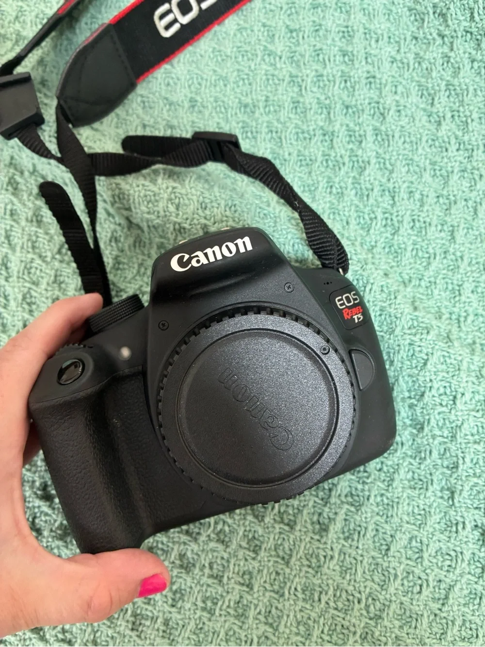 Canon DSLR Camera Body in Black with Red Strap Accents and kit lens.